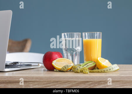 Frische Früchte, Gläser für Getränke und Maßband auf Tabelle der Ernährungsberaterin in Office Stockfoto