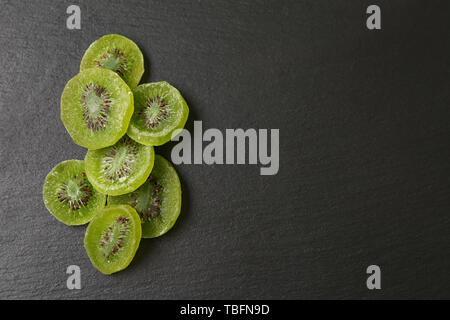Leckere getrocknete Kiwi auf dunklem Hintergrund Stockfoto