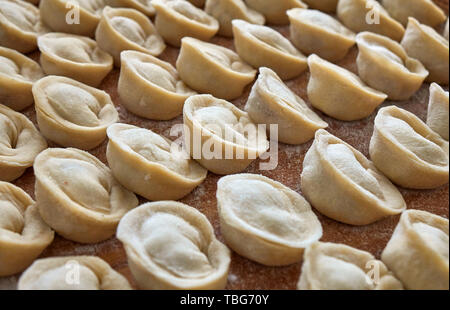 Hausgemachte russische Knödel, die Maultaschen, in Mehl auf der Holzplatte abgedeckt Stockfoto