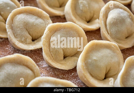 Hausgemachte russische Knödel, die Maultaschen, in Mehl auf der Holzplatte abgedeckt Stockfoto