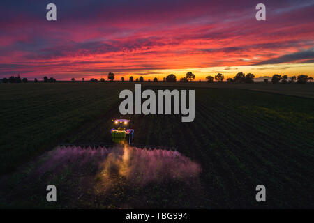 Traktor spritzen Feld am Frühling, Luftaufnahme Stockfoto