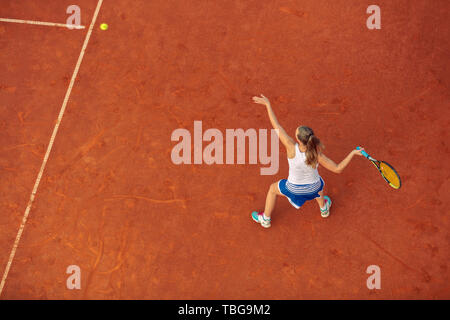 Luftaufnahme eines weiblichen tennis player auf einem Hof bei übereinstimmen. Junge Frau Tennis spielen. Hoher Blickwinkel betrachten. Stockfoto