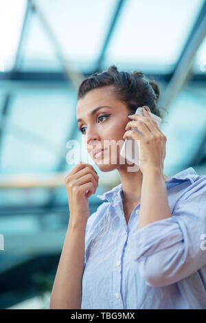 wunderschöne Frau telefonieren mit Handy am Flughafen Stockfoto