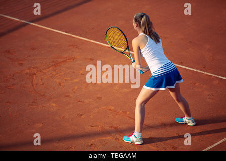 Luftaufnahme eines weiblichen tennis player auf einem Hof bei übereinstimmen. Junge Frau Tennis spielen. Hoher Blickwinkel betrachten. Stockfoto