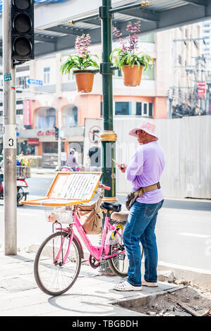 Ein lotterielos Verkäufer reisen durch Bangkok auf seinem Fahrrad Verkauf von Tickets an der Sukhumvit Rd. Thailand. Stockfoto