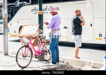 Ein lotterielos Verkäufer reisen durch Bangkok auf seinem Fahrrad Verkauf von Tickets an der Sukhumvit Rd. Thailand. Stockfoto