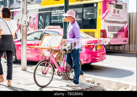 Ein lotterielos Verkäufer reisen durch Bangkok auf seinem Fahrrad Verkauf von Tickets an der Sukhumvit Rd. Thailand. Stockfoto