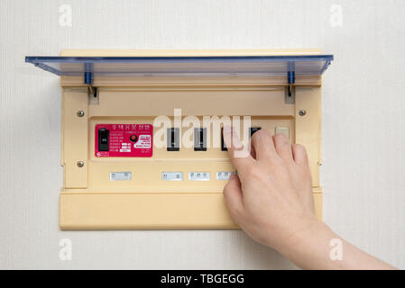 Der Elektriker an Hand öffnet Leistungsschalter. Elektrische Sicherheit Konzept. Stockfoto