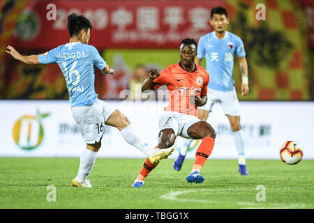 Kenianische Fußballspieler Ayub Masika, rechts, von Peking Renhe passt den Ball gegen einen Spieler von Tianjin Tianhai in Ihrem 12. Runde während der 2019 chinesischen Fußballverband Super League (CSL) in Peking, China, 1. Juni 2019. Peking Renhe besiegt Tianjin Tianhai 2-0. Stockfoto