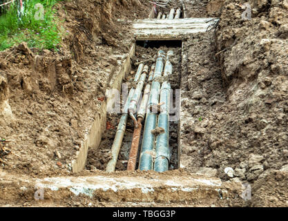 Austausch der alten, abgenutzten Wasserleitungen in einem besiedelten Gebiet unter der Erde. Stockfoto