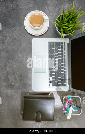 Blick von oben auf die Business Schreibtisch mit Laptop, Kaffee, Topfpflanze, Notebook und Zubehör im Büro Stockfoto