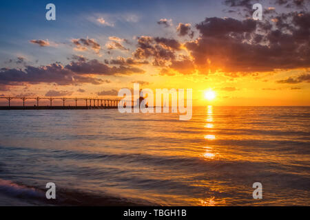 Atemberaubenden Sonnenuntergang mit dramatischen Wolken über Michigan City East Pierhead Leuchtturm, Washington Park Beach, Michigan City, Indiana Stockfoto