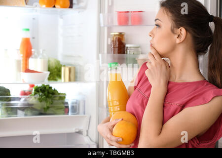 Frau das Essen aus dem Kühlschrank zu Hause Stockfoto