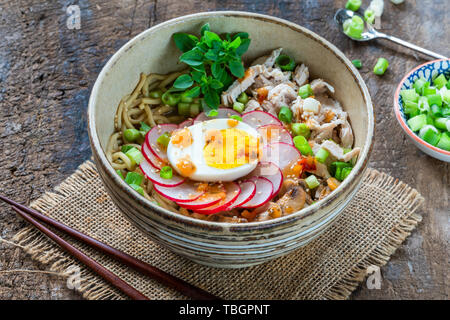 Ramen Nudeln mit Huhn, Ei, Pilze und Rettich sprinkeld mit Chilisauce und Sesam - Hohe Betrachtungswinkel Stockfoto