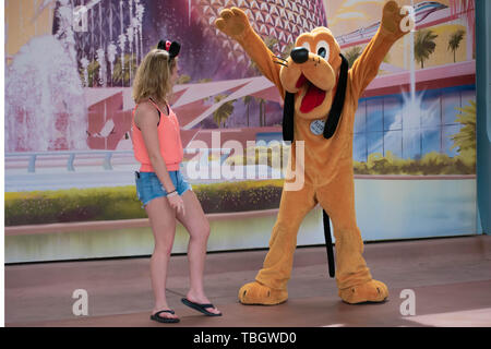 Orlando, Florida. März 27, 2019. Pluto spielen mit Mädchen in Epcot in Walt Disney World. Stockfoto