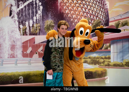 Orlando, Florida. 27. März 2019. Pluto umarmen junge Epcot in Walt Disney World. Stockfoto
