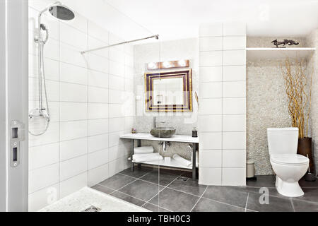 Modernes Interieur Badezimmer mit Waschbecken und Spiegel, Glas begehbare Dusche mit Marmor Fliesen Surround Stockfoto