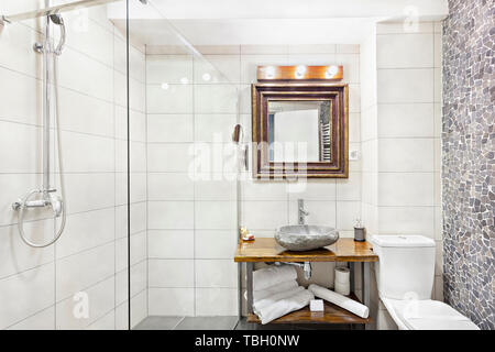 Modernes Interieur Badezimmer mit Waschbecken und Spiegel, Glas begehbare Dusche mit Marmor Fliesen Surround Stockfoto