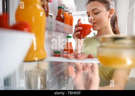 Frau Essen aus dem Kühlschrank zu Hause, Ansicht von innen Stockfoto