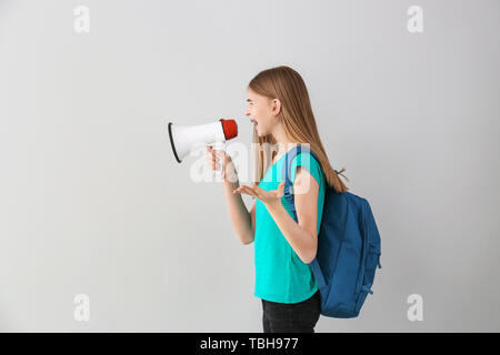 Portrait von cute Teenager mit Megafon auf hellen Hintergrund Stockfoto