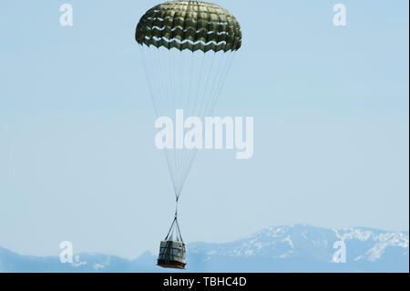 Ein Container Delivery System bundle landet auf der Drop Zone wie der Erhebung Charlie 29. Mai 2019 bekannt, bei der malmstrom Air Force Base, Mont die CDS Bundle durch eine C-130 Hercules Transportflugzeuge von der Montana Air National Guard fallengelassen wurde, 120 Airlift Wing. (U.S. Air Force Foto von Devin Doskey) Stockfoto