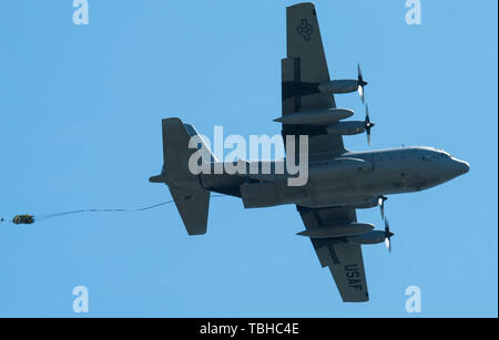 Eine C-130 Hercules Transportflugzeuge von der Montana Air National Guard 120 Luftbrücke Flügel fällt eine schwere Last auf dem Flug Linie vom 29. Mai 2019, an der Malmstrom Air Force Base, Mont Die MANG Einheit verwendet Malmstrom Flug Linie als Drop Zone bekannt als Laden Charlie, Routine airdrop Training Missionen durchzuführen. Die Drop Zone spiegelt die fortgesetzte Partnerschaft zwischen MAFB und die MTANG. (U.S. Air Force Foto von Devin Doskey) Stockfoto