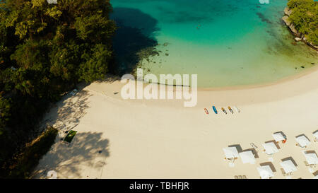 Tropischer Strand mit Sonnenliegen in der Nähe der Lagune mit türkisblauem Wasser Boracay, Philippinen, Luftbild. Meereslandschaft mit Strand auf der tropischen Insel. Sommer und Reisen Urlaub Konzept. Stockfoto