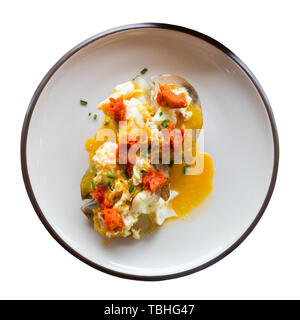 Ember - gebackene Kartoffel mit würzigen Wurst, Pastete und Eier, auf Platte. Auf weissem Hintergrund Stockfoto
