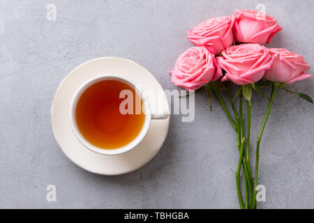 Tasse Tee mit rosa Rose. Ansicht von oben. Kopieren Sie Platz. Grauen Stein Hintergrund. Stockfoto