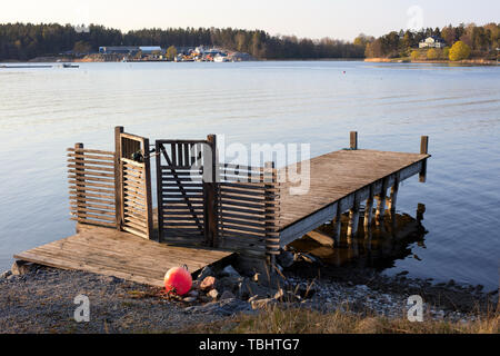 Holzsteg in Styrmansholmen, Karlsudd, bei Vaxholm, Schweden, während eines späten Frühlingnachmittages Stockfoto