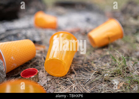 Orange einweg Kunststoff Glas oder Becher für Trinkwasser in einem Fach - Umweltproblem Konzept verwendet. Nicht kompostierbare Abfälle. Nach einem Picknick.natur Stockfoto