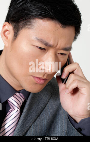 Ein männlicher Angestellter verwendet ein Mobiltelefon. Stockfoto