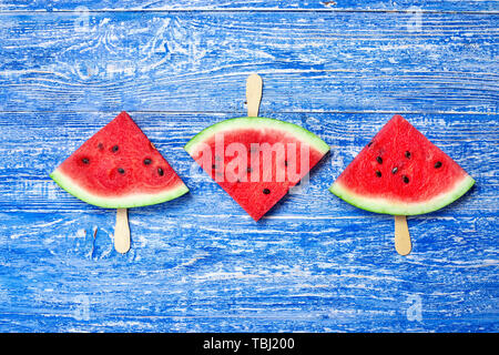 Wassermelone schnitt in einem Dreieck Form mit einem Stock auf einen frischen Blau Holz- Hintergrund Stockfoto