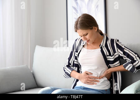 Junge Frau mit Schmerzen zu Hause Stockfoto