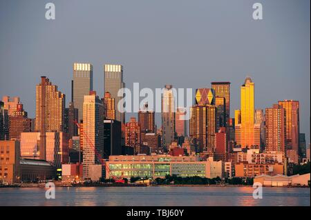 New York City Manhattan Sonnenuntergang Panorama mit historischen Wolkenkratzern über Hudson River mit schönen roten Farbe Sonnenschein Reflexion von New Jersey Weehawken Waterfront angesehen. Stockfoto