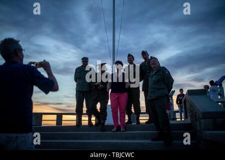 Arromanches-Les-Bains, Frankreich. 02 Juni, 2019. 01. Juni 2019, France (Frankreich), Arromanches-Les-Bains: Männer aus Aachen können fotografiert werden mit einer Dame in der ursprünglichen historischen uns bei Sonnenuntergang auf Gold Beach Uniformen. Nach der Landung der alliierten Truppen eine der zwei künstliche Häfen (Mulberry B) gebaut wurde an der Küste von Arromanches-les-Bains, durch die Truppen und liefert an Land gebracht wurden. 06.06.2019 ist der 75. Jahrestag der Landung der alliierten Truppen in der Normandie (D-Day). Quelle: dpa Picture alliance/Alamy leben Nachrichten Stockfoto