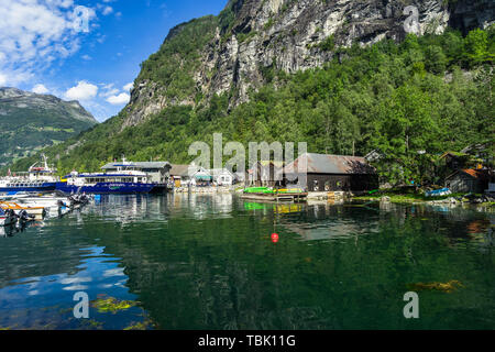 Anzeigen von Geiranger Dorf mit Sightseeing Boote an den kleinen Hafen. Geiranger, Sunnmore, Mehr og Romsdal, Norwegen, August 2018 Stockfoto