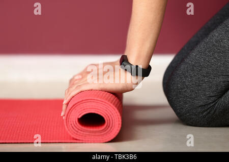 Junge sportliche Frau mit Yoga Matte in der Turnhalle, Nahaufnahme Stockfoto