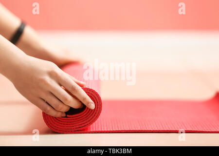 Junge sportliche Frau mit Yoga Matte in der Turnhalle, Nahaufnahme Stockfoto