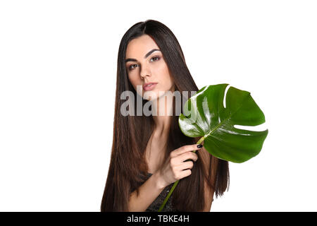 Porträt der schöne junge Frau mit gesunden langen Haaren Holding tropischen Blatt auf weißem Hintergrund Stockfoto