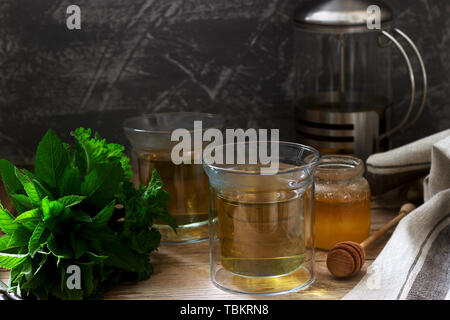 Kräutertee aus Minze und Melisse mit Honig im Glas Tassen. Rustikaler Stil, selektiven Fokus. Stockfoto