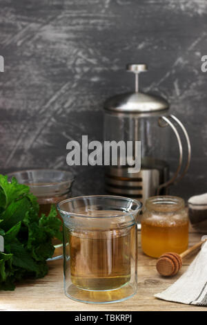Kräutertee aus Minze und Melisse mit Honig im Glas Tassen. Rustikaler Stil, selektiven Fokus. Stockfoto