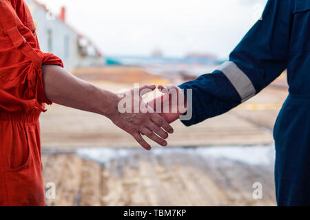 Marine Auftragnehmer Geschäftsmann handshaking Mit arbeiter auf dem Schiff. Stockfoto