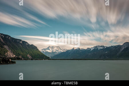 Lange Belichtung Bild der dramatischen Abend Wolken über die schneebedeckten Berge des Cime de l'Est", Haute Cime und Mont Ruan hinter den Genfer See in der Schweiz Stockfoto