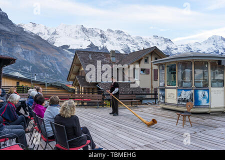 Alphorn Leistung in der Nähe der Alpes Berge Stockfoto