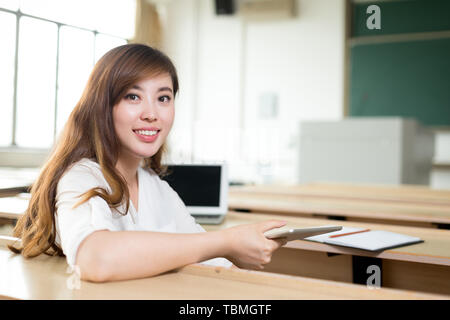 Asiatische schöne Frau mit Tablette im Klassenzimmer Stockfoto