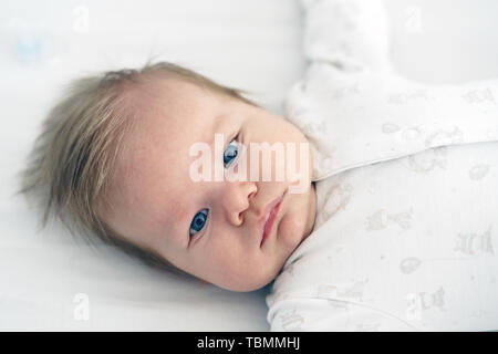 Ein neugeborenes Baby liegt in der Baumschule auf dem Bett Stockfoto