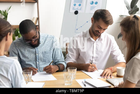 Glücklich lächelnde diverse Geschäftsleute die Unterschrift auf Papier Stockfoto