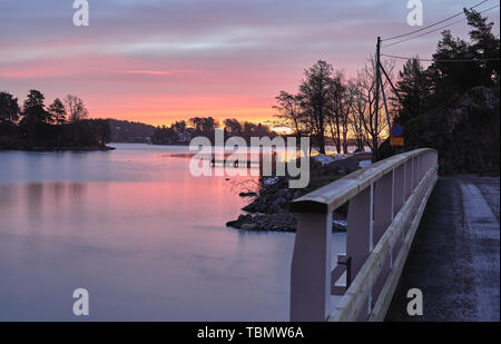 Lila wolkiger Sonnenaufgang hinter Styrmansholmen, Karlsudd, bei Vaxholm, Schweden Stockfoto