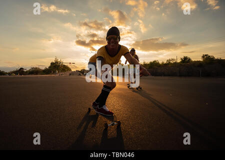 Junge Skateboarder fahren nachts auf Skateboards Stockfoto